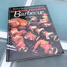 Load image into Gallery viewer, Better Homes and Gardens is known for its fabulous cookbooks. This hardcover cookbook focuses on their all time favourite barbecue inspired recipes. Its 96 pages are filled with amazing recipes along with many colour photographs. Originally published by Meredith Corporation, USA, 1977. This is the fourth printing 1984. In great vintage condition with normal age-related yellowing.