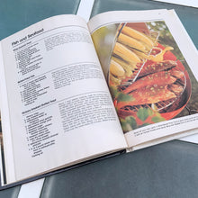 Load image into Gallery viewer, Better Homes and Gardens is known for its fabulous cookbooks. This hardcover cookbook focuses on their all time favourite barbecue inspired recipes. Its 96 pages are filled with amazing recipes along with many colour photographs. Originally published by Meredith Corporation, USA, 1977. This is the fourth printing 1984. In great vintage condition with normal age-related yellowing.