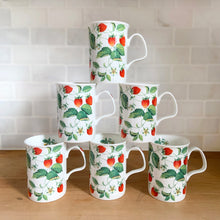 Load image into Gallery viewer, Six Roy Kirkham Alpine Strawberry bone china mugs stacked in a pyramid formation, three rows high, showing full botanical strawberry vine pattern on white subway tile background