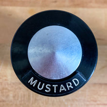 Load image into Gallery viewer, Vintage aluminum mustard spice shaker with black lid featuring the name of the spice in white. Crafted by Kromex, USA, circa 1950s. A fabulous example of mid-century design and style! In vintage condition with age appropriate wear. Measures 2 1/4 x 4 inches
