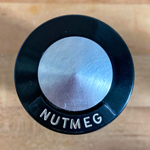 Load image into Gallery viewer, Vintage aluminum nutmeg spice shaker with black lid featuring the name of the spice in white. Crafted by Kromex, USA, circa 1950s. A fabulous example of mid-century design and style! In vintage condition with age appropriate wear. Measures 2 1/4 x 4 inches