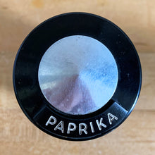 Load image into Gallery viewer, Vintage aluminum paprika spice shaker with black lid featuring the name of the spice in white. Crafted by Kromex, USA, circa 1950s. A fabulous example of mid-century design and style! In vintage condition with age appropriate wear. Measures 2 1/4 x 4 inches