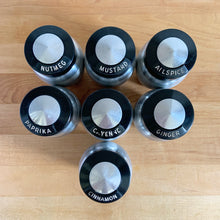 Load image into Gallery viewer, Vintage aluminum spice shaker with black lid featuring the name of the spice in white. Crafted by Kromex, USA, circa 1950s. A fabulous example of mid-century design and style! In vintage condition with age appropriate wear. Measures 2 1/4 x 4 inches
