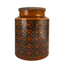 Load image into Gallery viewer, This highly sought after vintage amber and brown Bronte ceramic canister features a graphic repeating pattern of circles, dots and swirls. Designed by John Clappison for Hornsea Pottery, England, 1973. A great way to keep your kitchen decor looking stylish!
In excellent condition, no chips/cracks/repairs. Marked on the bottom, Hornsea England 1973 BRONTE.
Measures 6 x 7 3/4 inches