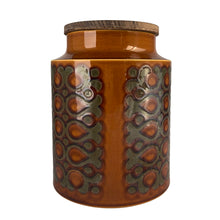 Load image into Gallery viewer, This highly sought after vintage amber and brown Bronte ceramic canister features a graphic repeating pattern of circles, dots and swirls. Designed by John Clappison for Hornsea Pottery, England, 1973. A great way to keep your kitchen decor looking stylish!
In excellent condition, no chips/cracks/repairs. Marked on the bottom, Hornsea England 1973 BRONTE.
Measures 6 x 7 3/4 inches