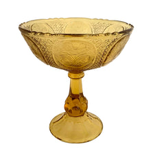 Load image into Gallery viewer, Antique Art Nouveau style amber pressed glass pedestal compote featuring 6 floral medallions, diamond star pattern on a thick pedestal and foot. Catalog number 1180. Crafted by Zabcowice Glassworks, Poland, 1910. This piece would look grand filled with fruit as a table centrepiece or fill with pine cones for display on your entranceway table....the decor possibilities are endless!
In excellent condition, no chips.
Measures 9 x 9 1/2 inches