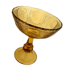 Load image into Gallery viewer, Antique Art Nouveau style amber pressed glass pedestal compote featuring 6 floral medallions, diamond star pattern on a thick pedestal and foot. Catalog number 1180. Crafted by Zabcowice Glassworks, Poland, 1910. This piece would look grand filled with fruit as a table centrepiece or fill with pine cones for display on your entranceway table....the decor possibilities are endless!
In excellent condition, no chips.
Measures 9 x 9 1/2 inches