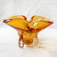 Load image into Gallery viewer, Vintage hand blown amber art glass ashtray. Crafted in Murano, Italy, 1960s. Perfect to use as intended or repurpose as a catchall or candy bowl and a lovely way to add mid mod style to your home's decor.
In good used vintage condition. A few minor flea bites at the base which are barely noticeable. The bottom is polished smooth.
Measures 6 3/4 x 4 x 4 inches