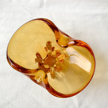Load image into Gallery viewer, Vintage hand blown amber art glass ashtray. Crafted in Murano, Italy, 1960s. Perfect to use as intended or repurpose as a catchall or candy bowl and a lovely way to add mid mod style to your home's decor.
In good used vintage condition. A few minor flea bites at the base which are barely noticeable. The bottom is polished smooth.
Measures 6 3/4 x 4 x 4 inches
