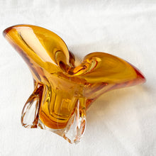 Load image into Gallery viewer, Vintage hand blown amber art glass ashtray. Crafted in Murano, Italy, 1960s. Perfect to use as intended or repurpose as a catchall or candy bowl and a lovely way to add mid mod style to your home's decor.
In good used vintage condition. A few minor flea bites at the base which are barely noticeable. The bottom is polished smooth.
Measures 6 3/4 x 4 x 4 inches