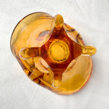 Load image into Gallery viewer, Vintage hand blown amber art glass ashtray. Crafted in Murano, Italy, 1960s. Perfect to use as intended or repurpose as a catchall or candy bowl and a lovely way to add mid mod style to your home's decor.
In good used vintage condition. A few minor flea bites at the base which are barely noticeable. The bottom is polished smooth.
Measures 6 3/4 x 4 x 4 inches
