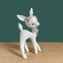 Load image into Gallery viewer, Adorable vintage mid-century era anthropomorphic deer ceramic figurine, glazed in iridescent white with blue rhinestone eyes, pink and blue flowers and gold gilt spaghetti details. Crafted by Lefton, Japan, circa 1950s. This sweet-faced deer is sure to delight everyone and it will make a wonderful addition to your Christmas holiday decor!
In good vintage condition. There is a chip to one blue flower, but otherwise excellent. Marked Japan and number 5845.
Measures 3 1/2 x 2 1/2 x 7 inches