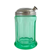 Load image into Gallery viewer, RARE FIND!
Antique uranium green depression glass sugar dispenser with chrome lid. Paden City Glass, USA, 1915. Lid by Elite Works Brass. The glass glows brilliantly under black light. A stunning piece of vintage history to add to your glass collection...a real gem!
In good vintage condition, no chips, minor flea bites around the collar where the lid meets the glass and age-related wear to the lid.
3 3/8 x 5 1/2 inches