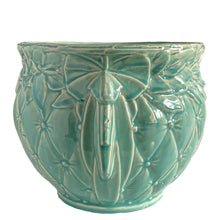 Load image into Gallery viewer, Large vintage TIerra Cushion jardiniere planter pot, aqua gloss glaze, features an overlapping floral leaf pattern around the top rim, a diamond quilted body and ribbon handles. Crafted by McCoy Pottery, USA, 1950s. A must-have for any McCoy collector or gardener!
In excellent condition, free from chips, cracks or repairs, with a manufacturer's defect at the rim, see photo. Maker's mark is on the bottom.
Measures 8 3/4 x 7 1/2 inches