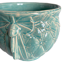 Load image into Gallery viewer, Large vintage TIerra Cushion jardiniere planter pot, aqua gloss glaze, features an overlapping floral leaf pattern around the top rim, a diamond quilted body and ribbon handles. Crafted by McCoy Pottery, USA, 1950s. A must-have for any McCoy collector or gardener!
In excellent condition, free from chips, cracks or repairs, with a manufacturer's defect at the rim, see photo. Maker's mark is on the bottom.
Measures 8 3/4 x 7 1/2 inches