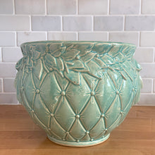 Load image into Gallery viewer, Large vintage Tierra Cushion jardiniere planter pot, aqua gloss glaze, features an overlapping floral leaf pattern around the top rim, a diamond quilted body and ribbon handles. Crafted by McCoy Pottery, USA, 1950s. A must-have for any McCoy collector or gardener!
In excellent condition, free from chips, cracks or repairs, with a manufacturer's glaze pops and like defects, see photo. Maker's mark.
Measures 9 x 7 1/4 inches