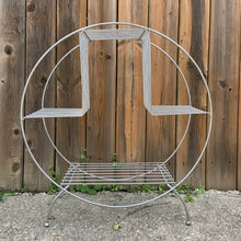 Load image into Gallery viewer, Vintage mid-century Art Deco wire circular hoop plant stand in silver with ball feet. Perfect for displaying plants, books and decor. Add atomic flair to your indoor or outdoor decor with this piece crafted in the 1950s. In excellent vintage condition. Shows signs of age, and has some wear spots. Measures 24 x 10 x 27 inches