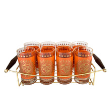 Load image into Gallery viewer, Side angle of 1960s Celestial Aztec Sun highball glass set in brass caddy showing atomic age sunburst design and wooden handle detail