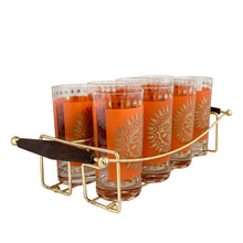 Load image into Gallery viewer, Angled view of Jeannette Glass Celestial Aztec Sun highball glasses showing dimensional sunburst pattern and 22K gold rim detail, 1960s atomic age design