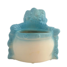 Load image into Gallery viewer, Vintage baby boy ceramic planter, shape 92. This sweet planter features a baby boy in blue diaper holding a rattle, leaning against a blue ruffled edged pillow. Crafted by Hull Pottery, USA, 1950s. Perfect for a houseplant or to use as nursery decor or as a practical holder for baby's accessories. In excellent condition, no chips. Measures 5 1/4 x 4 1/2 x 5 1/2 inches