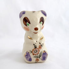 Load image into Gallery viewer, Adorable vintage miniature hand painted bear figurine featuring rosy cheeks, pink floral decals and gold gilt accents on a cream ground. Crafted by Shawnee Pottery, circa 1950s. This wee figurine is one of those rare, hard-to-find pieces that will make a delightful addition to your home's decor....perfect for a child's nursery!