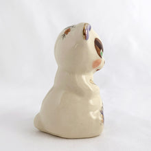 Load image into Gallery viewer, Adorable vintage miniature hand painted bear figurine featuring rosy cheeks, pink floral decals and gold gilt accents on a cream ground. Crafted by Shawnee Pottery, circa 1950s. This wee figurine is one of those rare, hard-to-find pieces that will make a delightful addition to your home's decor....perfect for a child's nursery!
