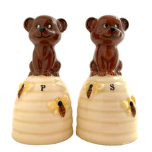 Load image into Gallery viewer, Vintage anthropomorphic bears on beehives ceramic salt and pepper shakers with plastic stoppers. Japan, 1970s. Add these adorable kitschy shakers to your collection!
In as found vintage condition, chip on bottom rim of one shaker, no cracks/repairs. Marked Japan.
Measures 2 1/4 x 2 1/4 x 4 1/2 inches