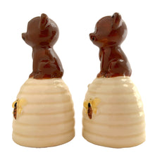 Load image into Gallery viewer, Vintage anthropomorphic bears on beehives ceramic salt and pepper shakers with plastic stoppers. Japan, 1970s. Add these adorable kitschy shakers to your collection!
In as found vintage condition, chip on bottom rim of one shaker, no cracks/repairs. Marked Japan.
Measures 2 1/4 x 2 1/4 x 4 1/2 inches