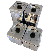 Load image into Gallery viewer, Angled top view of vintage BeautyWare 4-piece chrome canister set with black knob lids, mid-century kitchen decor