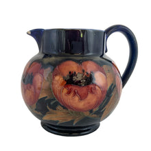 Load image into Gallery viewer, Vintage art nouveau "Big Poppy" pitcher featuring tubelined poppy flowers hand painted in muted shades of red on a cobalt blue ground. Crafted by Moorcroft Pottery, England, 1930s. A stunning piece of art pottery! In as found vintage condition with a chip to one side of the spout, see photos. Still great for display or have it repaired by a professional restorationist. Blue William Moorcroft signature with impressed mark "Made in England". 5 3/8 x 4 1/2 inches (incl. handle)