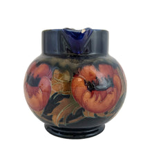 Load image into Gallery viewer, Vintage art nouveau "Big Poppy" pitcher featuring tubelined poppy flowers hand painted in muted shades of red on a cobalt blue ground. Crafted by Moorcroft Pottery, England, 1930s. A stunning piece of art pottery! In as found vintage condition with a chip to one side of the spout, see photos. Still great for display or have it repaired by a professional restorationist. Blue William Moorcroft signature with impressed mark "Made in England". 5 3/8 x 4 1/2 inches (incl. handle)