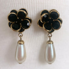 Load image into Gallery viewer, A stunning pair of vintage black faceted cut crystal stud earrings fashioned into flowers set in gold-toned metal with drop faux pearls. Crafted by Swarovski, Austria, 1980s. Wear them alone or paired with other vintage pieces for effortless glamour. A beautiful example of classic Swarovski craftsmanship, this piece offers luxury sparkle at a fraction of the cost of fine gemstones. Perfect for collectors, romantic outfits, or anyone who loves classic crystal jewelry with timeless appeal.