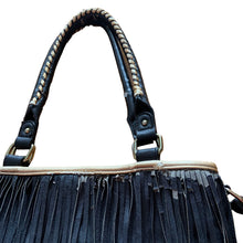 Load image into Gallery viewer, Vintage boho style black faux leather purse with fringe detail, tan interior with one zippered and two open pockets, snap closure. Crafted by Steve Madden.
In as found vintage condition with overall wear, interior is stained, see photos.
Measurements with handles 13 x 28 inches
Measurements without handles 13 x 16 1/2 inches