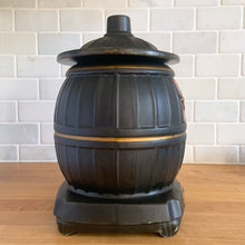 Load image into Gallery viewer, This vintage figural ceramic black pot belly stove cookie jar was crafted by McCoy Pottery in the 1960s. It's a must-have for any McCoy collector looking to add charm to their vintage cottage or farmhouse kitchen decor. This cookie jar is a perfect example of McCoy's expertise in creating high-quality and timeless pieces.
In excellent condition, no chip/cracks/repairs. There are a few tiny spots of glaze misses/loss.
Measures 6 3/4 x 7 x 10 3/8 inches