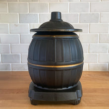 Load image into Gallery viewer, This vintage figural ceramic black pot belly stove cookie jar was crafted by McCoy Pottery in the 1960s. It's a must-have for any McCoy collector looking to add charm to their vintage cottage or farmhouse kitchen decor. This cookie jar is a perfect example of McCoy's expertise in creating high-quality and timeless pieces.
In excellent condition, no chip/cracks/repairs. There are a few tiny spots of glaze misses/loss.
Measures 6 3/4 x 7 x 10 3/8 inches
