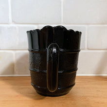 Load image into Gallery viewer, RARE! Gothic Victorian black pressed glass creamer jug. The lower 2/3 are stippled between smooth bands, while the top 1/3 is smooth. Produced by Davidson's, England, c1890 - 1910. A great piece to start a collection! In excellent vintage condition, free from chips/cracks/repairs. There is a manufacturer's defect on the underside of the foot near the mold line. Measures 2 3/4 x 3 1/2 inches (not including handle)