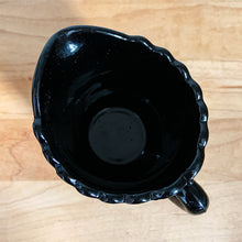 Load image into Gallery viewer, RARE! Gothic Victorian black pressed glass creamer jug. The lower 2/3 are stippled between smooth bands, while the top 1/3 is smooth. Produced by Davidson's, England, c1890 - 1910. A great piece to start a collection! In excellent vintage condition, free from chips/cracks/repairs. There is a manufacturer's defect on the underside of the foot near the mold line. Measures 2 3/4 x 3 1/2 inches (not including handle)