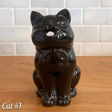 Load image into Gallery viewer, Vintage mid-century era redware ceramic cat creamer, featuring a figural seated cat, glazed is glossy black with a brown undertone and hand painted green eyes. Crafted by Shafford, Japan, 1950s. This kitschy creamer pours from the open mouth and works equally well as a decorative display piece. A solid example of postwar Japanese export ceramics with playful character and collectible appeal.
In excellent condition, no chips, cracks or repairs. Unmarked
Measures 5 1/4 x 3 x 5 1/2 inches