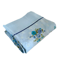 Load image into Gallery viewer, Lovely vintage blue flat bed sheet printed with a pattern of purple and teal flowers against a white geometric grid. This 50% polyester / 50% cotton sheet fits a double/full sized bed. Crafted by Wabasso, Canada, circa 1970s. A beautiful addition to your bedding collection, or repurpose for crafts, quilting or garment making.