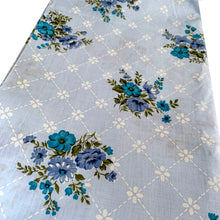 Load image into Gallery viewer, Lovely vintage blue flat bed sheet printed with a pattern of purple and teal flowers against a white geometric grid. This 50% polyester / 50% cotton sheet fits a double/full sized bed. Crafted by Wabasso, Canada, circa 1970s. A beautiful addition to your bedding collection, or repurpose for crafts, quilting or garment making.