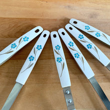 Load image into Gallery viewer, Close-up of six white melamine handles from vintage Japanese kitchen utensil set, teal blue floral and wheat stem pattern