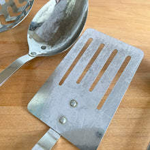 Load image into Gallery viewer, Close-up of vintage stainless steel slotted spatula and solid spoon from Japanese kitchen utensil set, riveted construction, age wear visible