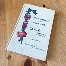 Load image into Gallery viewer, This vintage hardcover Blue Ribbon and Pure Gold Cook Book – For Everyday Use in Canadian Homes is a jam-packed collection of recipes using Pure Gold Manufacturing Company products. 158 pages filled with cooking techniques, hundreds of recipes and extensive index. 19th Edition, 1946 and retains one of the four original mail-in coupons at the front of the book. There are six pages of vibrant colour advertisements for Blue Ribbon and Pure Gold products.