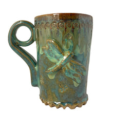 Load image into Gallery viewer, Vintage watery blue, green, ochre high fired drip glaze studio pottery mug featuring applied and debossed dragonflies with sculpted handle and scalloped base. Signed AA. This gorgeous one-of-a-kind handmade vessel is perfect for any hot beverage.
In excellent condition, no chips, cracks or repairs. Typical manufacturing glaze bubbles.
Measures 3 7/8 x 5 1/2 inches (5 7/8" incl. handle)
Capacity 16oz