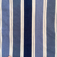 Load image into Gallery viewer, This queen-size blanket represents five decades of weaving mastery from Tissage MaGély Weaving in New Brunswick. Hand-loomed in wool and cotton by the Levesque family, its multi-blue and white striped pattern reflects the studio's commitment to traditional textile arts since 1973. Substantial enough for layering or as a primary bedcover, it delivers both visual character and genuine warmth—a functional heirloom piece for collectors of artisan-made home textiles.