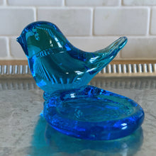 Load image into Gallery viewer, Lovely vintage hand blown art glass bluebird featuring a platform to hold a tea light or votive candle holder. Designed by artisan Leo Ward, his signature is on the bottom with the year 1987. Mr. Ward was the creator of Arkansas' Bluebird of Happiness and owner of Terra Studios in Arkansas. He crafted these much beloved bluebirds until his death at 89. In excellent condition, free from chips or cracks. Measures 4 x 3 3/4 x 2 1/2 inches