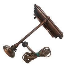 Load image into Gallery viewer, Antique wall hung metal picture light with adjustable blackened brass metal shade in a deep copper-brown. This heavy-weighted lamp affixes to the wall, adjustable either upward or downward at the wall plate and the light head is extends.
In as found vintage condition, in working order. We recommend all antique/vintage lighting be upgraded to current ESA standards by a license professional.
Measures 9 1/2 x 11 inches, extends to 17 1/2 inches