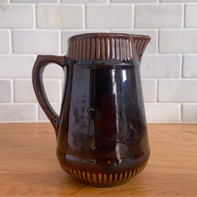 Load image into Gallery viewer, Vintage gloss brown stoneware pitcher with ribbed bands. Crafted by Medalta Stoneware, Canada, 1924. This utilitarian piece nicely complement any farmhouse or cottage kitchen!
In good vintage condition, no chips/cracks/repairs, age-related wear to the exterior. Unmarked.
Measures 5 x 5 1/2 inches