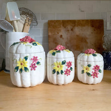 Load image into Gallery viewer, Rare set of three vintage mid-century white figural pumpkin squash ceramic canisters. These three dimensional beauties are hand painted with colourful butterflies and flowers. Each lid is topped with a floral finial. Enterprise Sales & Distributors import, Japan, 1960s. Perfect for the kitchen kitsch collectible enthusiast!