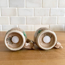 Load image into Gallery viewer, Vintage souvenir ceramic salt and pepper shakers featuring an embossed Canadian Mounted Police on horseback, green maple leaves and darling baby rabbit handles finished in tan coloured glaze. Crafted in Japan, 1950s. A sweet set of collectible shakers to use or display! In excellent condition, no chips/cracks/repairs. No corks. Measures 2 3/4 x 2 1/8 inches